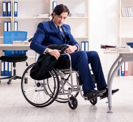 Young male employee in wheelchair working in the office