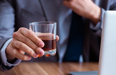Male employee drinking alcohol and smoking cigarettes at workpla