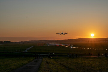 Fototapeta na wymiar Landing of an airplane at sunset