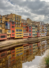 A view of Girona's colourful riverside buildings reflected in the River Onya