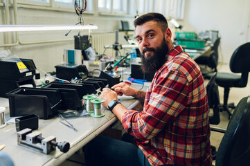 Electronics engineer working in a workshop with tin soldering parts