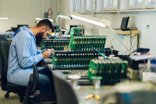 Electronics engineer working in a workshop with tin soldering parts - Powered by Adobe