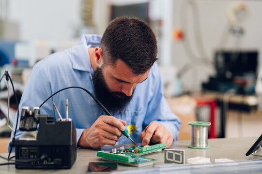 Electronics engineer working in a workshop with tin soldering parts