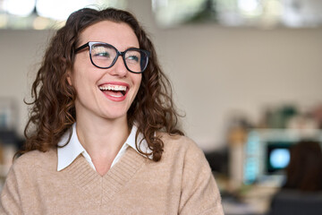 Young happy cheerful professional business woman, happy laughing female office worker wearing glasses looking away at copy space advertising job opportunities or good business services or optic store. - obrazy, fototapety, plakaty