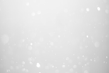 White glitter vintage lights background.  White bokeh shiny on dark background.