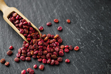 dry aromatic sumac spice on a black stone background