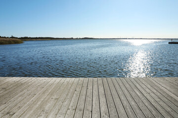 Fototapeta premium Beautiful view of wooden terrace near river on sunny day