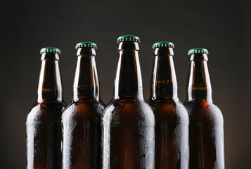 Many bottles of beer on dark background, closeup