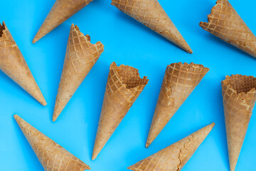 Empty ice cream cone on blue background.