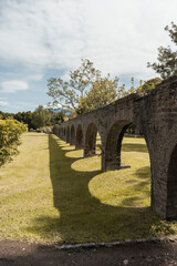 Fototapeta na wymiar Arcos de acueducto de hacienda colonial antigua con árboles y plantas