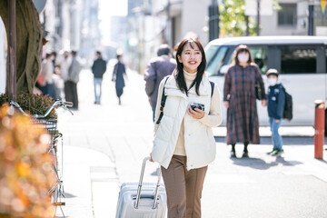 スーツケースをひいて歩く女性　trip