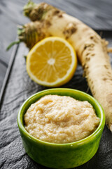 aromatic horseradish root on a black rustic wooden background