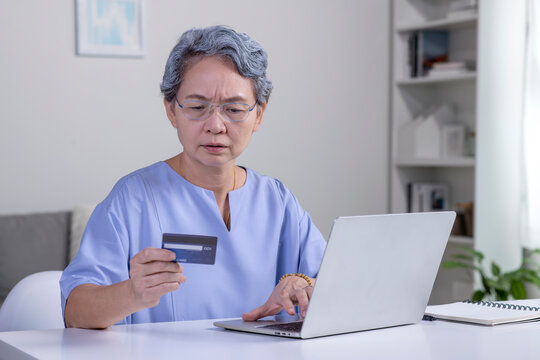 Confused Asian Elderly Senior Retired Woman, Stressed Worried Sad Frustrated Female Having Problem With Paying, Buying Online, Payments With Credit Blocked Bank Card, Laptop. Internet Fraud