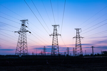 In the evening, the silhouette of high voltage towers