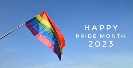 'HAPPY PRiDE MONTH 2023' on bluesky and rainbow flags background, concept for lgbtq+ celebrations in pride month, june, 2023.	