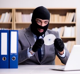 Criminal businessman wearing balaclava in office
