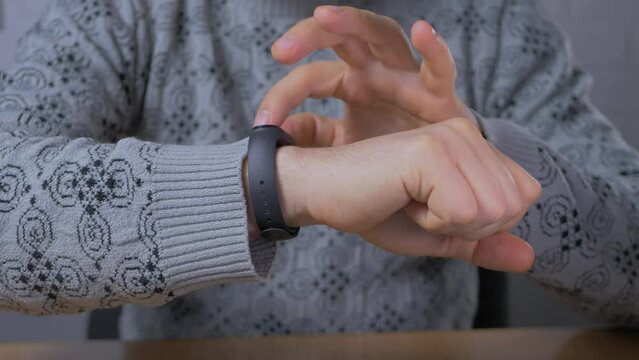 Male person using smart watch display in office. Fitness tracker on arn hand. Business district, professional occupation