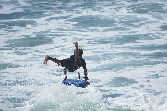 Boy Having Fun Jumping The Waves On A Boogie Board