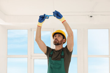 Electrician fixing wires with insulating tape indoors