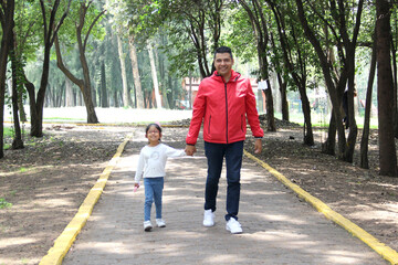 Latino divorced single dad and daughter walk in the park and spend quality time with physical...