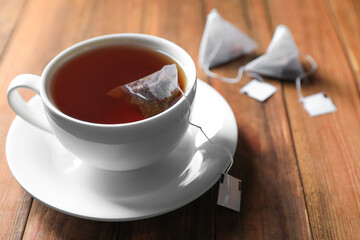 Tea bag in cup on wooden table, closeup