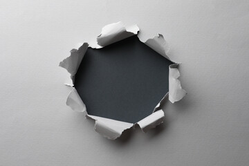 Hole in white paper on black background