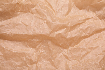 Texture of crumpled brown baking paper as background, top view