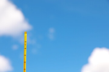Weather thermometer against blue sky, space for text