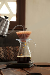 Preparing coffee at wooden table in cafe, closeup