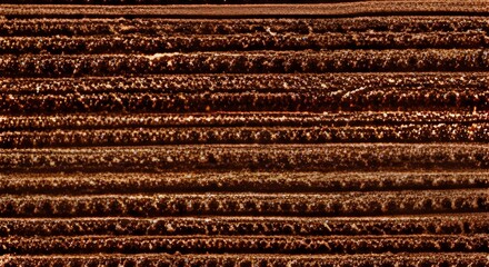 Brown textile texture background of a scratchy burlack material in an even light brown color.