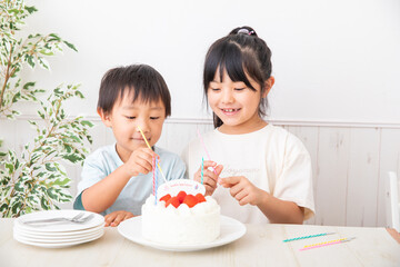 誕生日ケーキにローソクを立てる子供