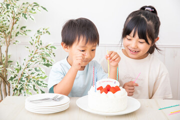 誕生日ケーキにローソクを立てる子供