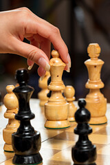 Close up of hand playing chess on wooden board © Moy Ortega