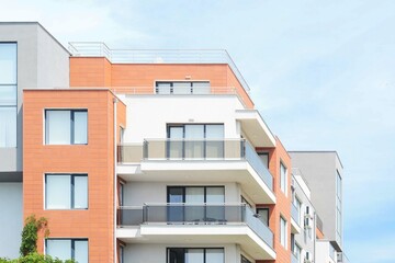 Exterior of residential building with balconies against blue sky