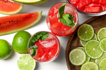 Tasty watermelon drink with lime and fresh ingredients on white table, flat lay