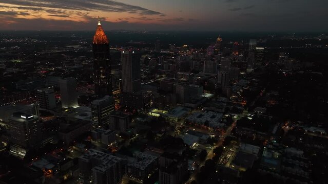 Atlanta Georgia skyline at night. Aerial establishing shot with colorful sunset at dusk. Lights on city skyscrapers.