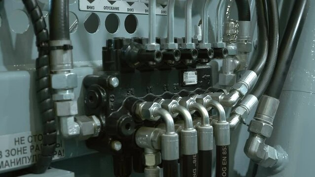 The block of hydraulic control valves of the new truck, which is responsible for the movement of the body, crane, winch, compaction of garbage. Shot in motion. Closeup