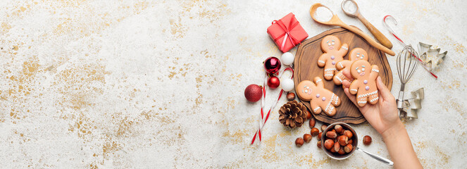 Female hand and composition with tasty Christmas cookies on light grunge background with space for...