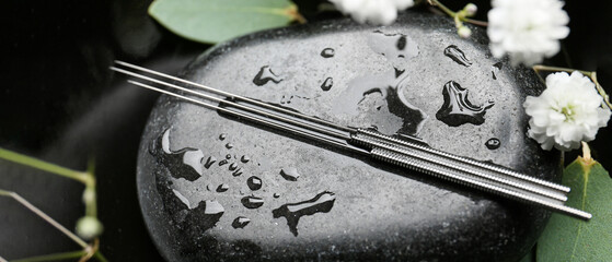 Acupuncture needles on spa stone, closeup