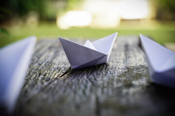 Origami, white paper boat isolated on a wooden floor. Paper boats mean walking. feeling of freedom...