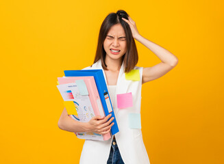 Boring young Asian woman holding document file and a sticky note on the shirt, stand on studio shot...