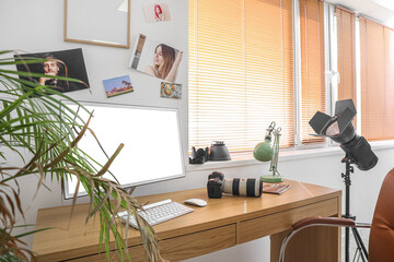 Photographer's workplace with computer and professional equipment in office