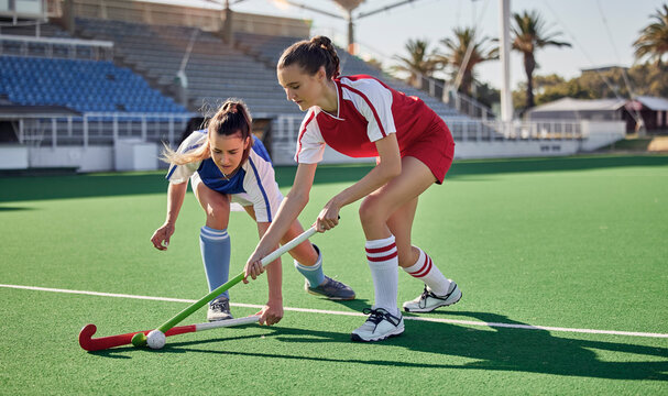 Sports fitness, field hockey game and women challenge for ball in stadium competition, club rival match or tournament contest. Training exercise, workout and athlete battle action on arena turf pitch - Powered by Adobe