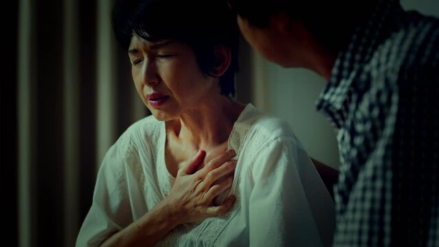 胸を押さえて苦しむ中年女性　医療イメージ