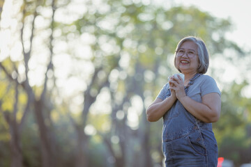 mature woman drinking tea and looking forward  in the park