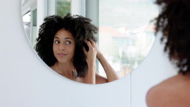 Hair, Hair Care And Black Woman With Afro By A Mirror In The Bathroom After Cleaning Or Washing With Shampoo Product. Happy, Beauty And African Girl Enjoys Grooming Natural Hair In A Daily Treatment