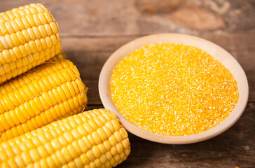 Corn grits polenta in a wooden bowl on old wooden table