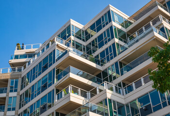 Modern apartment buildings exteriors in sunny day. Cityscape with facade of a modern housing construction with balconies