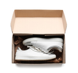 Cardboard box with sneakers on white background