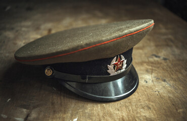 The cap of a Soviet soldier on a wooden table. A cockade with a red star. Tank officer's cap. - obrazy, fototapety, plakaty